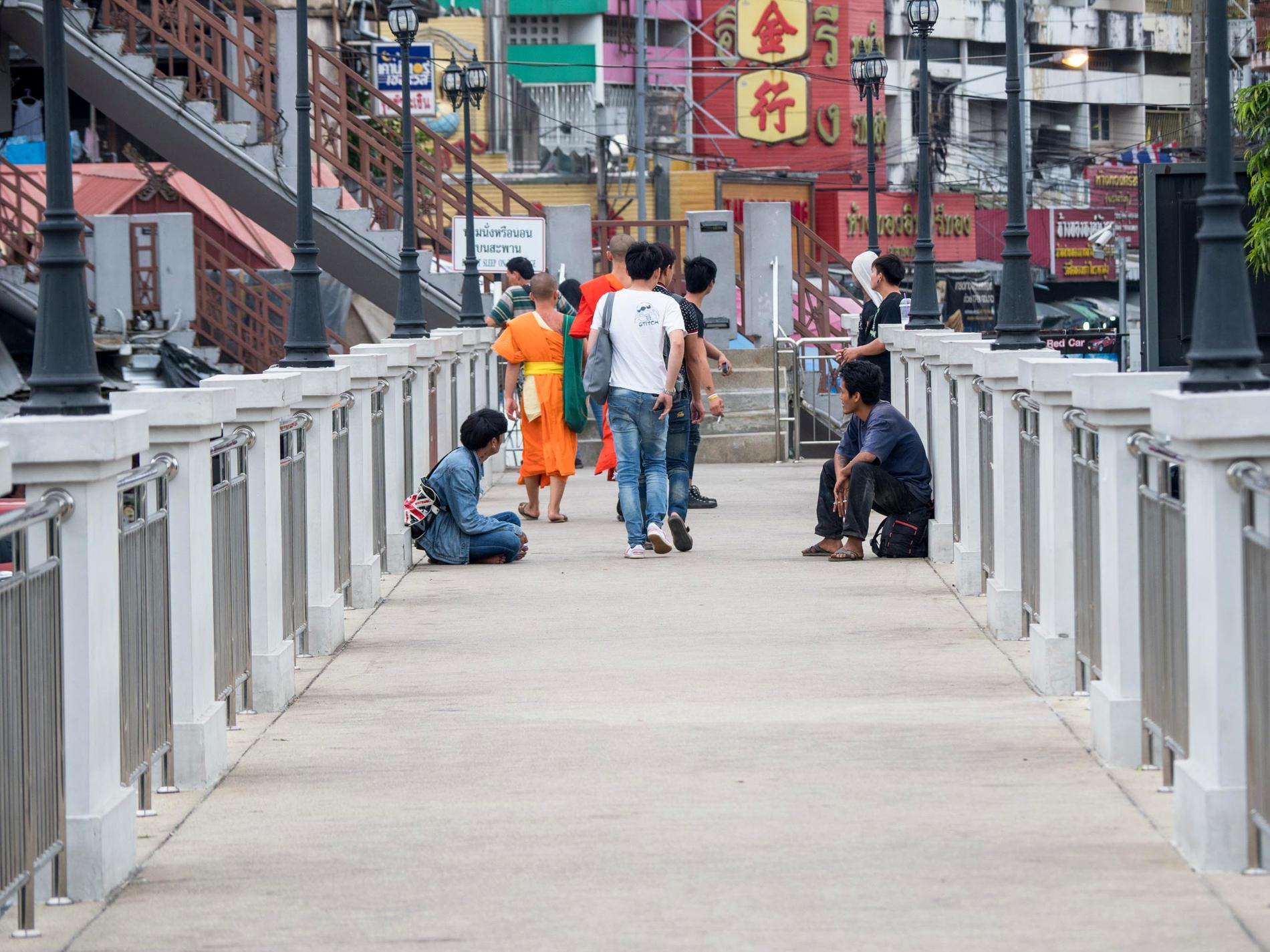 People crossing a bridge in a Chiang Mai neighbourhood.